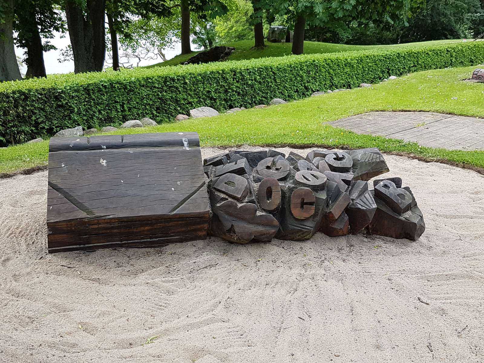 A wooden sculpture of a large book and letters to climb on at Sophienholm