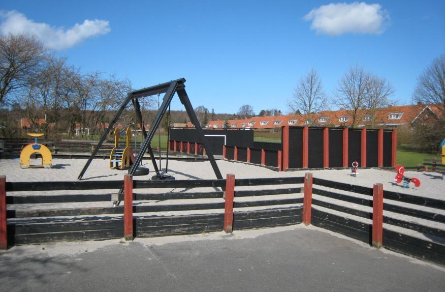 A ball court and swings at the playground at Lindevangen